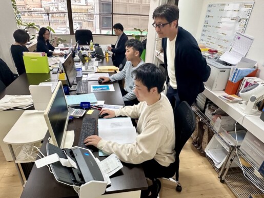 税理士事務所内でスタッフがレシートと通帳をスキャンし、AIが自動処理する近未来的なシーン